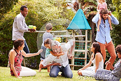 Adults and kids having fun playing in a garden Stock Photo