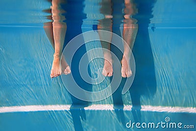 Adults legs underwater in the swimming pool Stock Photo