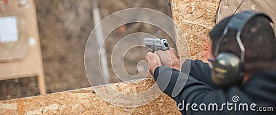 Advanced outdoor tactical shooting on target around barrier and wall Stock Photo