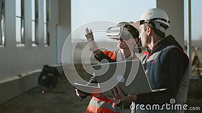 Advanced technologies, modern specialists, engineers and architect in helmets in VR gadget explores vertical reality of stock video footage Advanced technologies, modern specialists, engineers and architect in helmets in VR gadget explores vertical reality of stock video footage