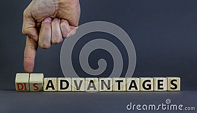 Advantages or disadvantages symbol. Businessman turns wooden cubes, changes the word Disadvantages to Advantages. Beautiful grey Stock Photo