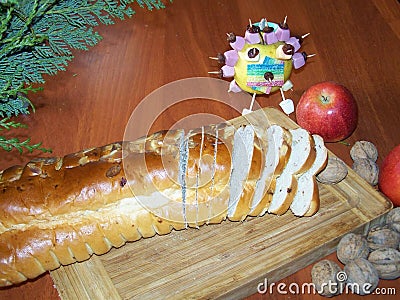 Advent still life with Christmas knit bread, apples and nuts. Apple decorated candies. On a wooden board table. Branch of conifer Stock Photo