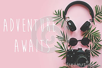 The Adventure Awaits text on stylish photo camera with green pal Stock Photo