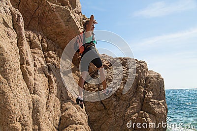 Adventure girl climbs on a cliff, rich the target Stock Photo