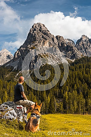 Adventure Man Sitting on Rock at Hiking Trial with Best Freind Dog Editorial Stock Photo