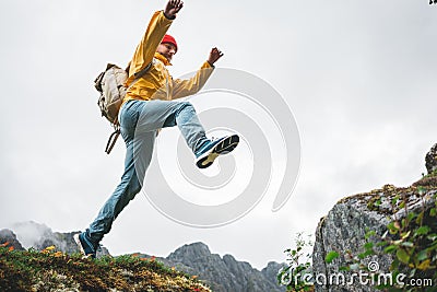 Adventure tourist jumping on rocks over cliff Stock Photo