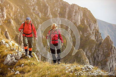 Adventure, travel, tourism, hike and people concept - smiling couple walking with backpacks outdoors Stock Photo