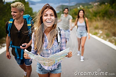 Adventure, travel, tourism and people concept - group of smiling friends with backpacks and map Stock Photo