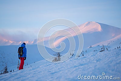 Adventurer, with backpack, stands on the mountain range Stock Photo