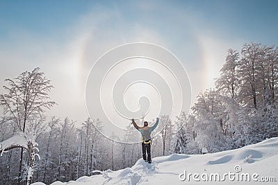 Adventurer enjoys an unusual natural phenomenon called the halo effect when the morning sun passes through frozen particles. Stock Photo