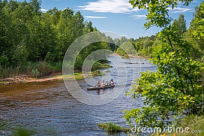 Adventuresome friends canoeing together on a beautiful river in a thick forest. Canoeing down beautiful river in Forest. Stock Photo