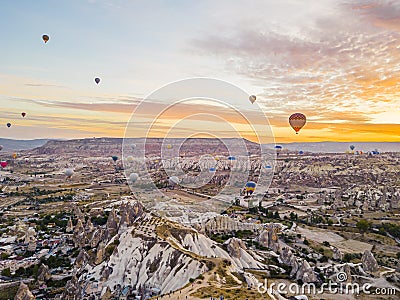 Adventurous summer holidays opportunity for tourists. Warm colourful sunrise illuminating the sky with hot-air balloons Stock Photo