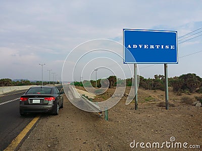 Advertise - Blank blue sign on a large pole against blue sky Stock Photo