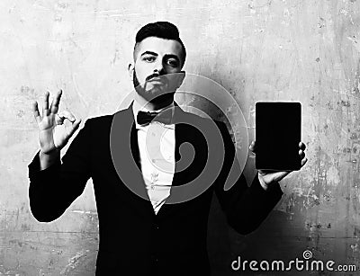 Advertiser with beard and confident face shows tablet and OK Stock Photo