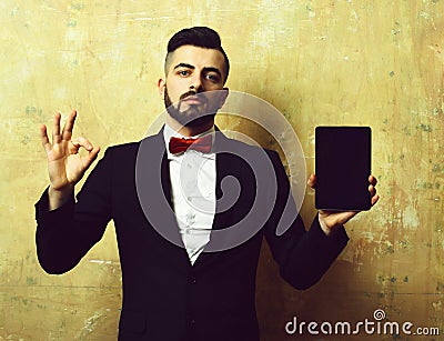 Advertiser with beard and confident face shows tablet and OK Stock Photo