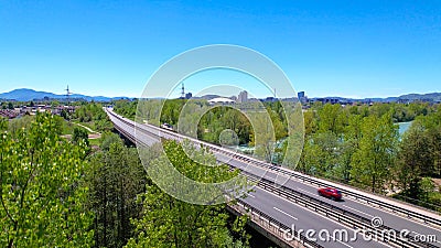 AERIAL: Asphalt freeway crosses the green landscape and leads towards Ljubljana. Stock Photo