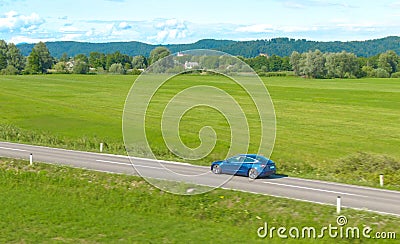 AERIAL: Cinematic shot of a new Tesla Model 3 driving itself down a country road Editorial Stock Photo