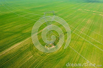 Aerial close-up view of electricity pylon with power lines over agricultural field Stock Photo