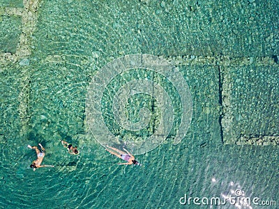 Aerial drone bird`s eye view photo of tourists snorkeling above old Sunken City of Epidauros, Greece Stock Photo