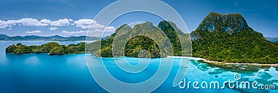 Aerial drone panoramic view of uninhabited tropical island with rugged mountains, rainforest jungle, sandy beaches Stock Photo