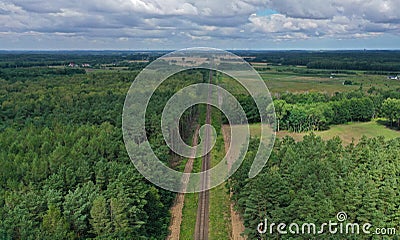 Aerial drone perspective view on straight railroad in rural scenery with green forest during summer Stock Photo