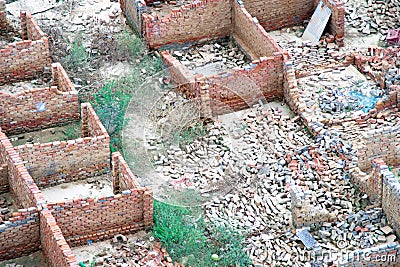 Aerial drone shot of broken demolished brickwork houses with fallen walls due to razing of illegal construction or natural Stock Photo