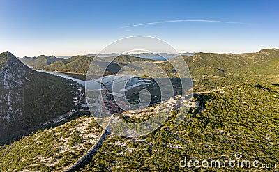 Aerial drone shot of Fortress of City of Ston on top of hill with view of Salt Pans in Croatia sunrise Stock Photo