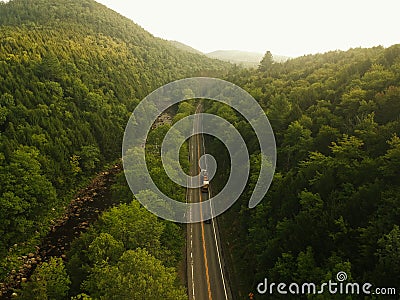 Aerial Drone shot of truck driving down a road in the misty Adirondack Mountains. Stock Photo