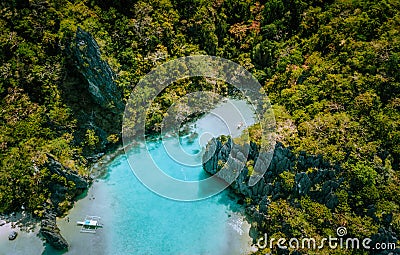 Aerial drone view of blue turquoise transparent lagoon water of tropical island with rugged steep mountains rocks Stock Photo