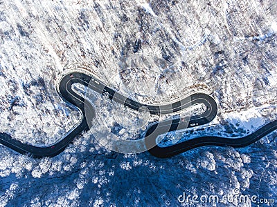 Aerial drone view of a curved winding road through the forest hi Stock Photo