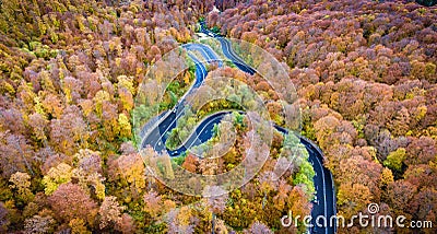 Aerial drone view of a curved winding road through the forest Stock Photo