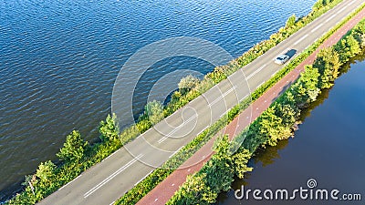Aerial drone view of motorway road and cycling path on polder dam, cars traffic from above, North Holland, Netherlands Stock Photo