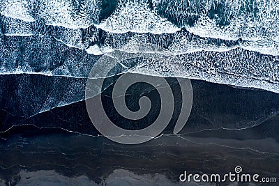 Aerial drone view of ocean waves washing black sand beach, Iceland Stock Photo