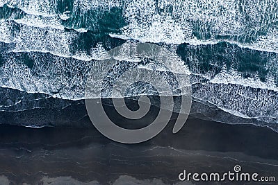 Aerial drone view of ocean waves washing black sand beach, Iceland Stock Photo