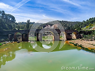 Aerial drone view of roman bridge in the hiking route of the water mills along the Odiel river from Sotiel Coronada Stock Photo