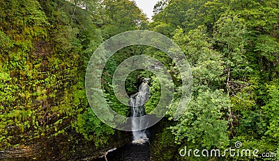 Aerial view of a tall waterfall in a narrow canyon surrounded by trees Sgwd Einion Gam, Wales, UK Stock Photo