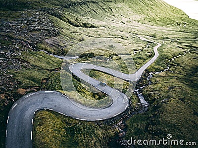Aerial drone view of zigzag road with one car in open space Stock Photo