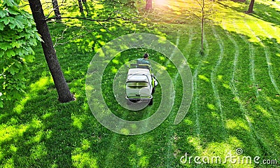 Aerial. Green grass trimming with professional lawn mower machine. Stock Photo
