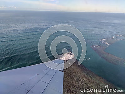 Aerial high in the sky shot of window view of plane leaving Hawaii Stock Photo
