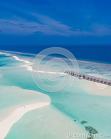 Aerial landscape, luxury tropical resort with water villas. Island beach, palm trees, sunny sky. Amazing bird eyes Stock Photo