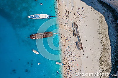 Aerial overhead drone shot of Zakynthos Navagio beach full of tourists and cruise ship in Ionian sea in Greece Stock Photo