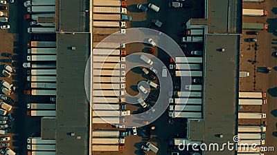 Aerial overhead shot of a big warehouse and many loading and unloading trailer trucks. Logistics concept Stock Photo