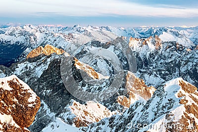 Brown and white snowy mountain tops in sunset Stock Photo