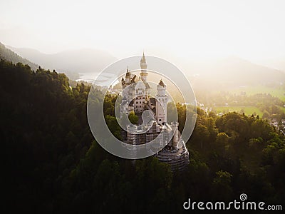 Aerial panorama sunset view of bavarian alpine mountain landscape with Neuschwanstein fairytale castle Fuessen Germany Editorial Stock Photo