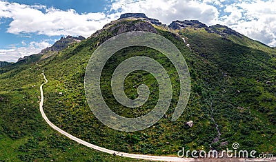 Aerial panorama view of the road for travelers on a motorcycle, car, incredible beauty views of green meadows and majestic Stock Photo