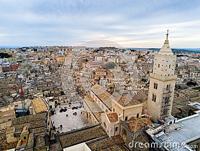 Aerial Panoramic View of the Belltower of the Cathedral of St. Maria La Bruna on Cloudy Sky at Sunset Stock Photo