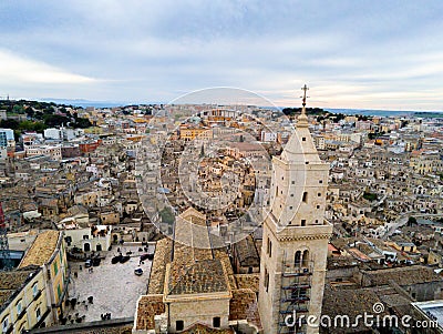 Aerial Panoramic View of the Belltower of the Cathedral of St. Maria La Bruna on Cloudy Sky at Sunset Stock Photo