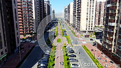 Aerial of people walking down the green alley in the summer city street. Motion. Flying along the road with buildings Editorial Stock Photo