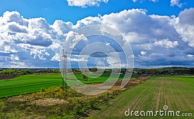 Aerial perspective view on rural landscape with house, forest, clouds, fields and electric power line tower Stock Photo