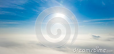 Aerial photo above the fog or white clouds with shining sun. Beautiful sunrise cloudy sky from aerial view. Above clouds from Stock Photo